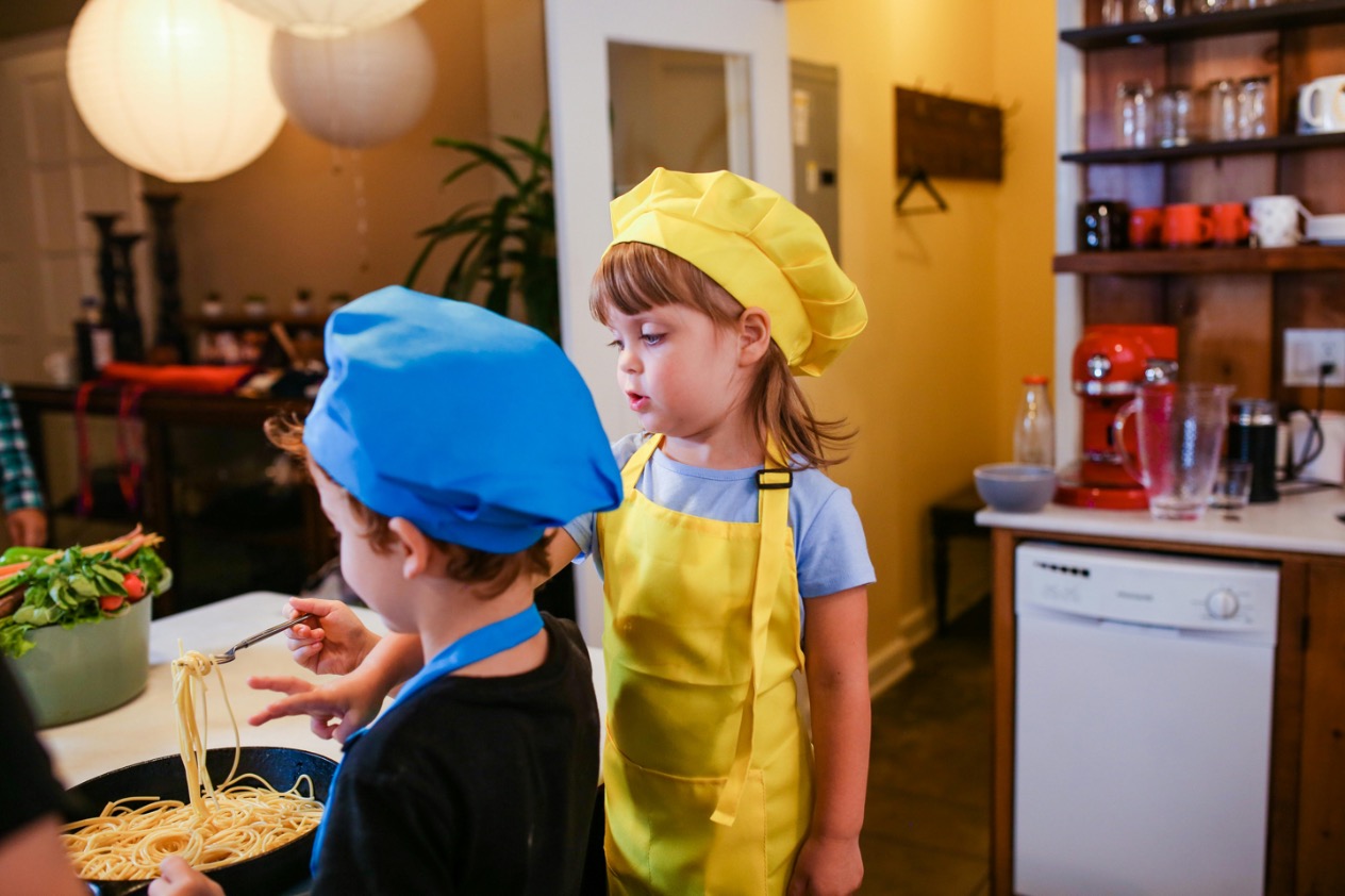 A culinary expert teaching children cooking skills, making culinary education fun and hands-on with interactive cooking experiences