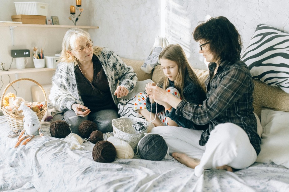 Group of enthusiastic participants learning crocheting techniques with colorful yarn and hooks