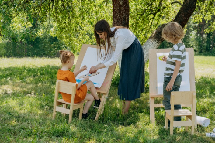 Children engaged in a painting class, showing their creativity with brushes and colorful paints on easels